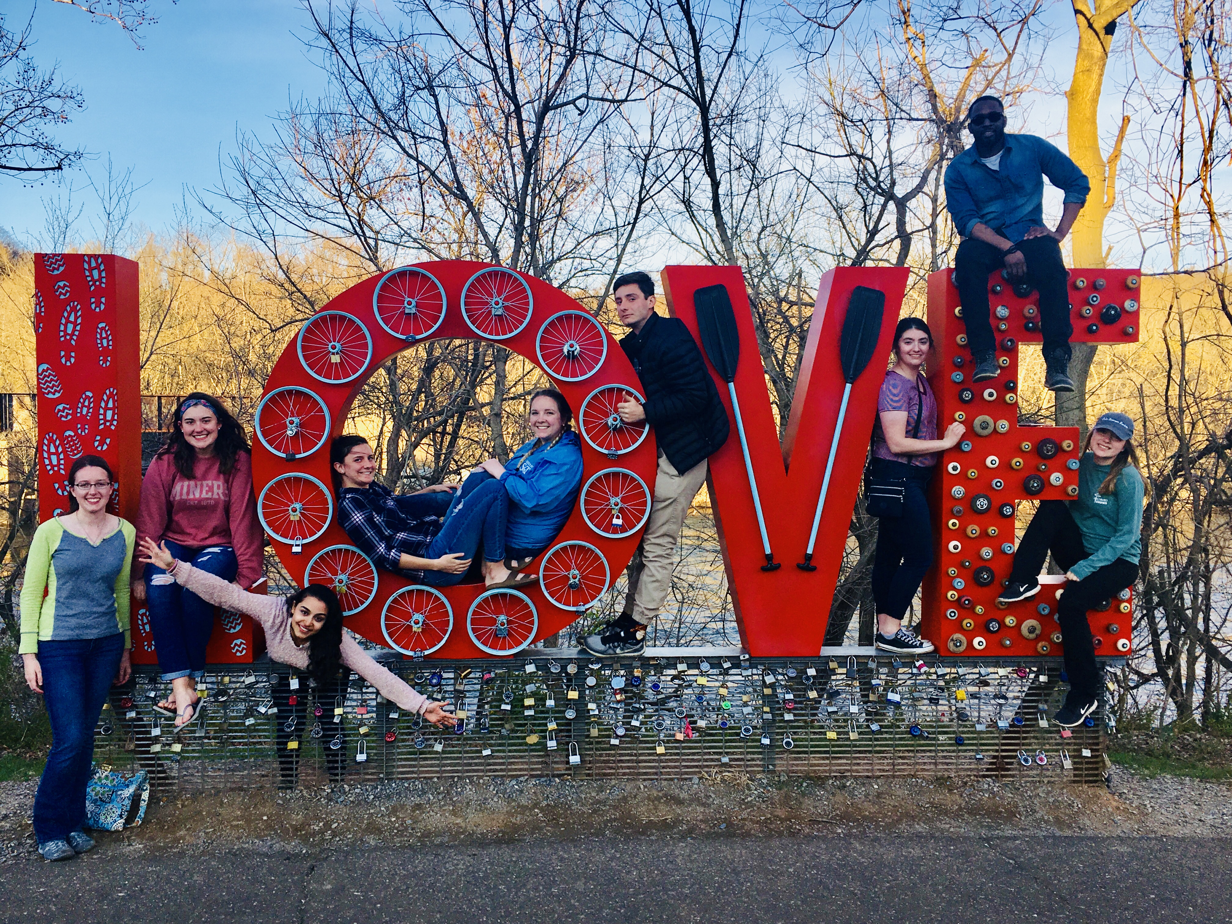 The 2018 team posing with a giant statue spelling out LOVE